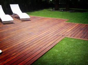 Suelo exterior en madera tropical en zona ajardinada junto piscina